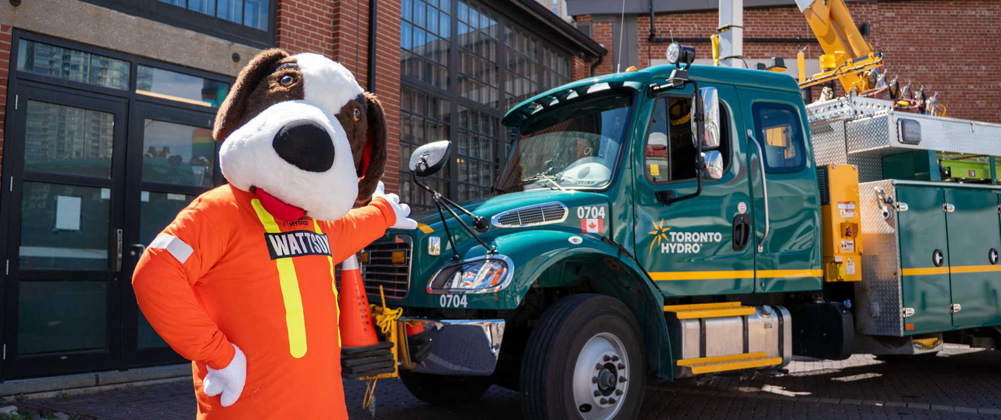 Toronto Hydro's mascot, Wattson standing infront of a bucket truck.