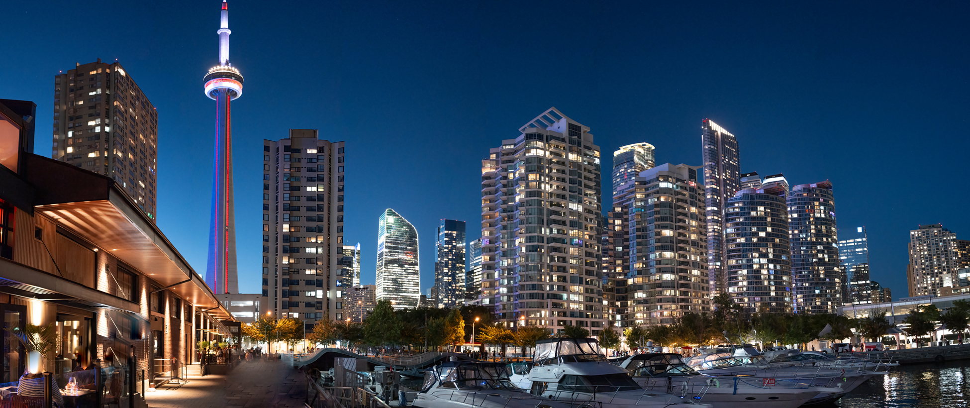 Toronto buildings, including the CN Tower, lit up at night.