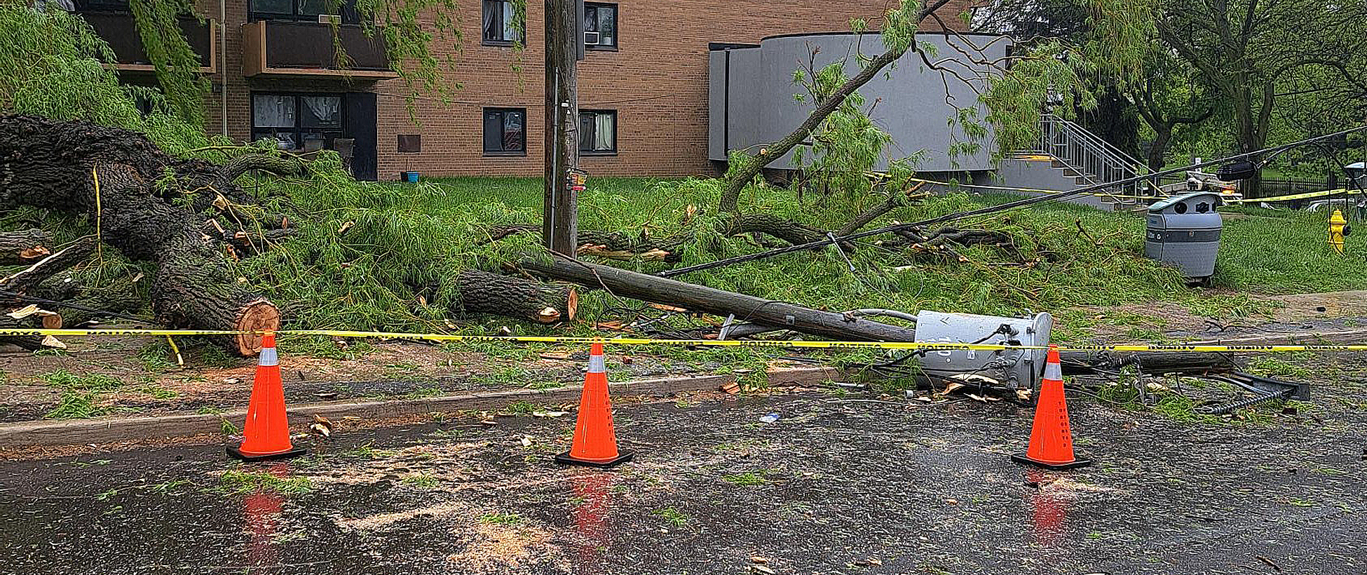 Outdoor scene of wires down and blocked off due to storm damage. 
