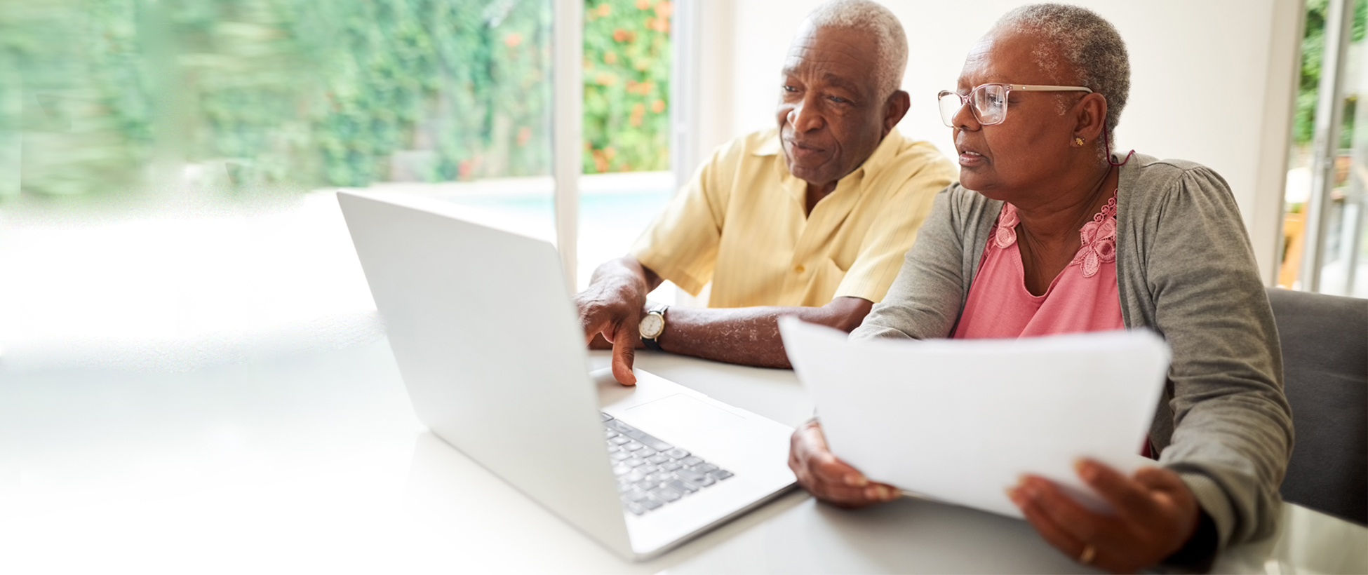 A couple reviewing paperwork and a laptop.