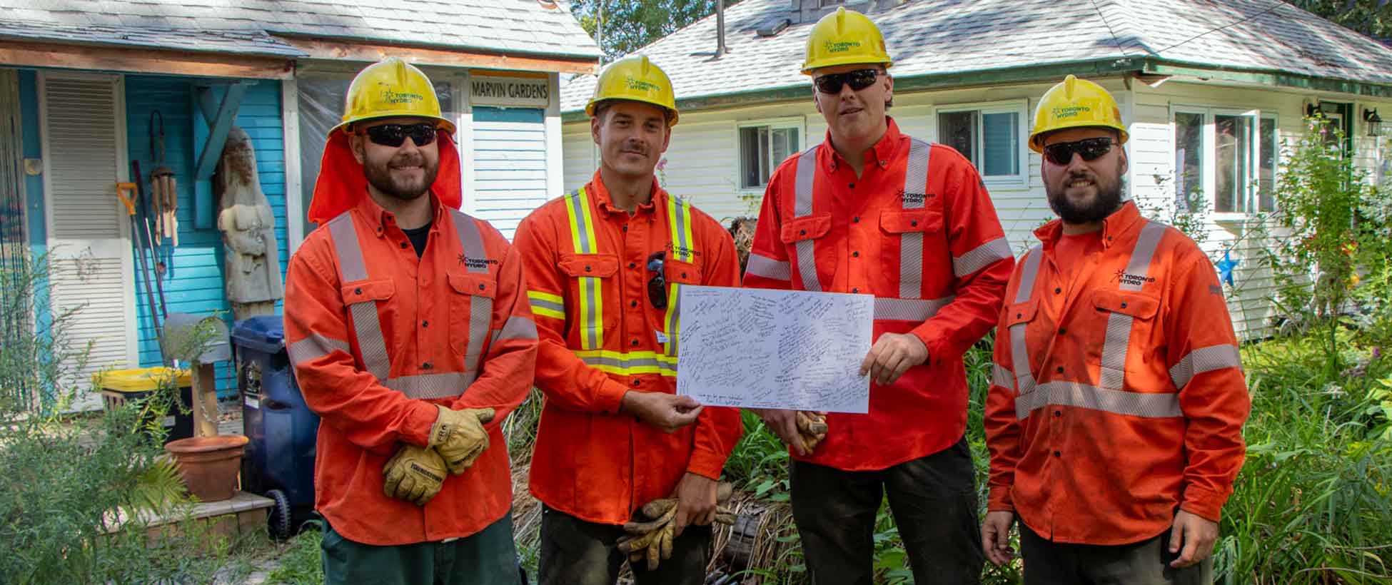 Toronto Hydro crews hold up a thank you card after restoring power.